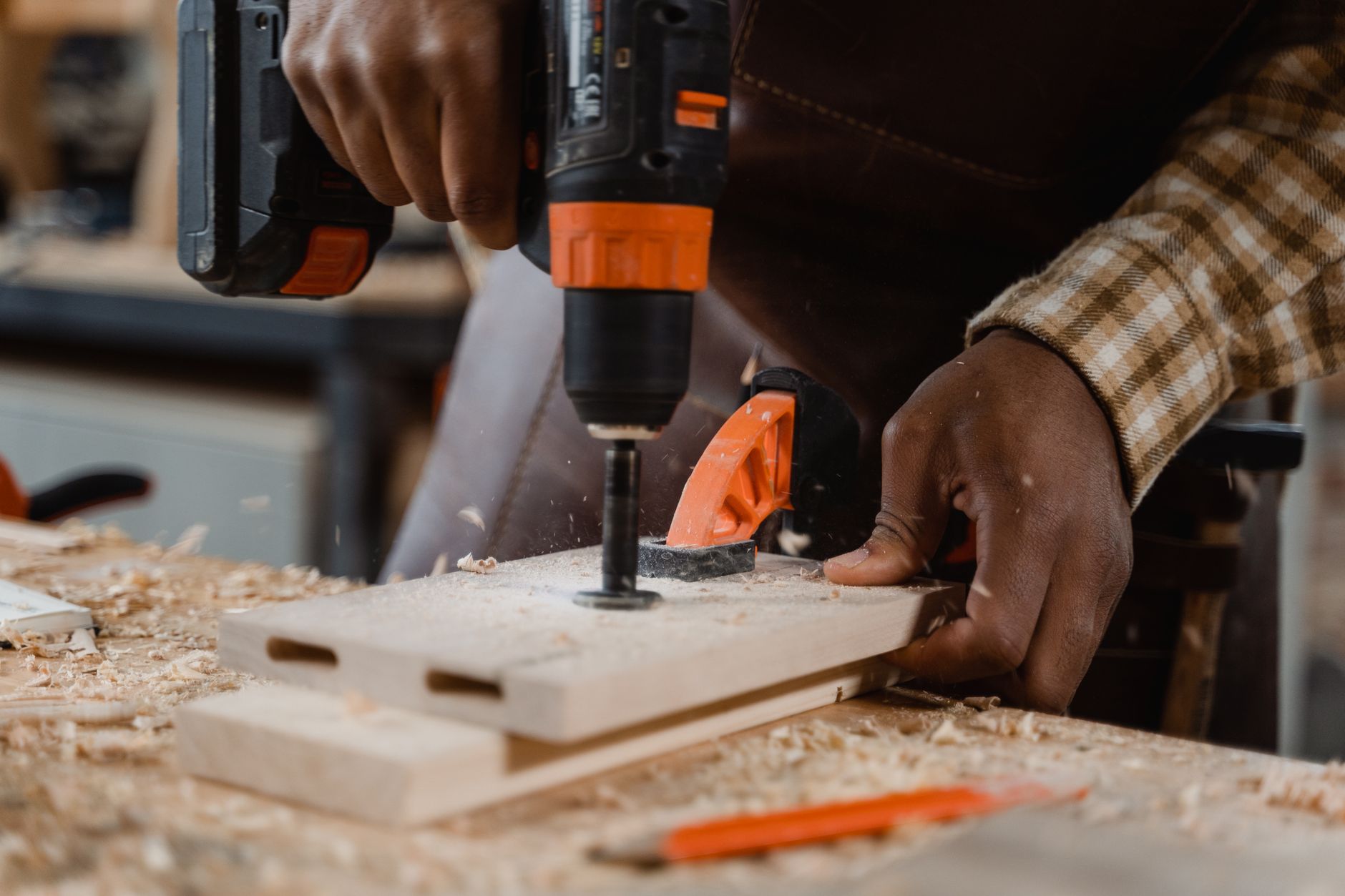 a person drilling a row of holes into a birch log with a cordless drill